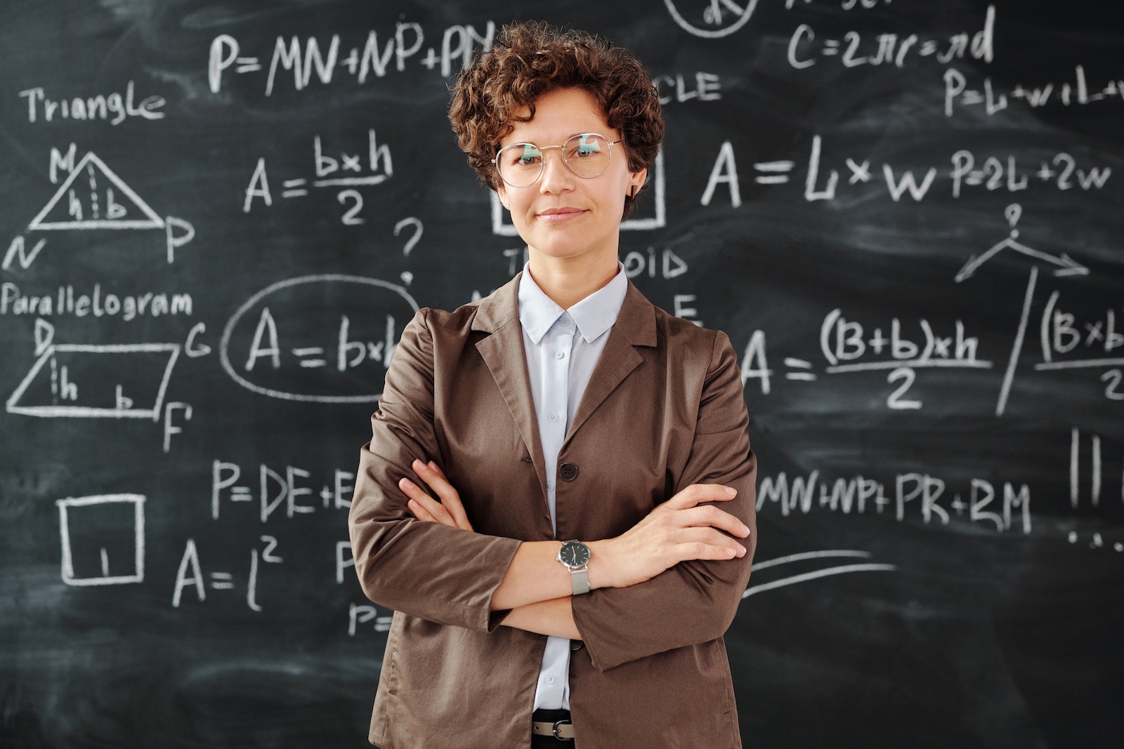 一名女教師站在充滿公式的黑板前